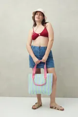 Top de bikini negro con textura, breteles finos y aro metálico en el centro del busto.