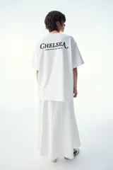 Remera blanca de algodón con cuello redondo y mangas cortas. Estampado frontal con la palabra "London" en letras negras con diseño ornamentado.