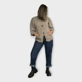 Saco de hilo tejido color negro, con mangas amplias tres cuartos y cuello alto, presenta un diseño abotonado.