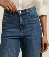 Pantalón de jean wide leg de tiro alto, color azul oscuro, con bolsillos delanteros y traseros, trabillas para cinturón y cierre frontal con cremallera y botón.