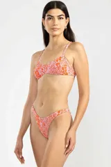 Conjunto de bikini con estampado animal print en tonos rosado y naranja. El corpiño es de estilo triángulo con breteles finos y la bombacha es de tiro bajo con corte en V.