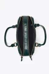 Bolso tipo bowling color verde oscuro charolado, con doble asa de mano y correa bandolera extraíble. Tiene doble compartimento con cierre de cremallera.
