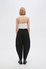 Pantalón blanco de poliéster, corte ancho, tiro alto y bolsillos laterales.
