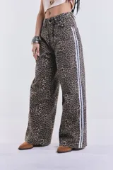 Pantalón de jean de corte ancho con estampado animal print y rayas blancas laterales.