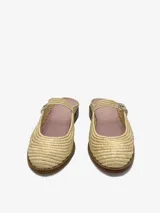Mules color beige confeccionadas en raffia tejida, con correa al tobillo con hebilla metálica.