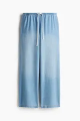 Pantalón denim celeste de corte ancho, con cintura elastizada y cordón ajustable.