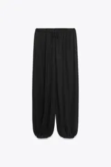 Pantalón bombacho negro de tiro alto con cintura elástica ajustable con cordones y puños elásticos en los tobillos.