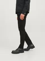Pantalón de jean negro de corte tapered, con cinco bolsillos y cierre con botón.