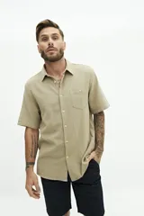 Camisa de manga corta color beige, con textura tipo crepé y cuello camisero.