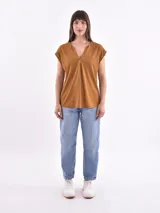 Blusa blanca de corte holgado, con cuello en V y mangas cortas.