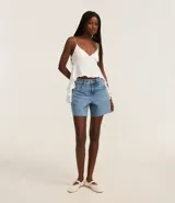 Short de jeans celeste con trabillas en la cintura, bolsillos y bajo deshecho. Presenta tachuelas en los bolsillos delanteros y laterales.