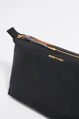 Neceser negro de nylon con estructura blanda y tamaño grande. Tiene cierre con cremallera, tirador de piel, logo metálico de la marca y un bolsillo interior.