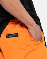 Pantalón naranja de corte holgado con bolsillos laterales, cintura elástica ajustable y tela suave.