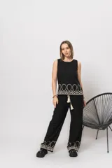 Pantalón negro de simil lino, con elástico en la cintura y bordados en la parte inferior.