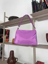 Cartera de lona semi impermeable color púrpura, con cierre metálico y bolsillo interno.