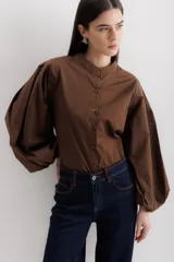 Camisa marrón de algodón con cuello mao, abotonada al frente y mangas largas abullonadas.