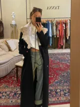 Tapado largo negro de paño elástico con cuello de cuero corderito genuino de color beige.