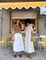 Falda midi blanca con lunares amarillos y bolsillos laterales.