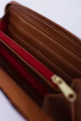 Billetera marrón con estampado de piel de serpiente, cierre perimetral, múltiples ranuras para tarjetas, documentos y billetes, y bolsillo interior con cierre para monedas.