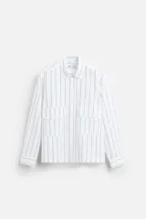 Camisa cropped fit confeccionada en tejido de algodón a rayas verticales negras sobre fondo blanco. Cuello solapa y manga larga acabada en puño con botones. Bolsillos frontales de plastrón con solapa. Cierre frontal de botonadura.