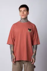 Remera color ladrillo de corte oversize, con mangas cortas y estampado de Mickey Mouse con letras orientales en el frente. Confeccionada en algodón pesado.