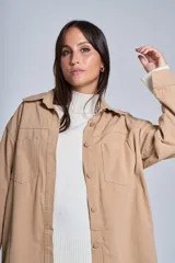 Sobrecamisa negra de gabardina con cuello camisero, cierre frontal con botones, mangas largas con puños abotonados y bolsillos de parche en el pecho.