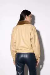 Chaqueta bomber de cuero color marrón, con cuello de piel sintética roja, cierre frontal con cremallera y bolsillos laterales.