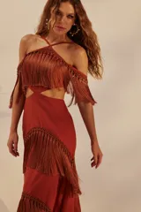 Vestido largo color ladrillo con escote halter, espalda descubierta y falda con tres niveles de flecos.