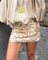 Minifalda color crema cubierta de lentejuelas.