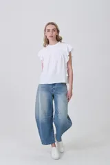 Blusa de viscosa color celeste, con cuello a la base, frunces y punto smock en el pecho y los hombros, y mangas cortas con volados.