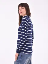 Polera de punto azul marino con rayas horizontales blancas, cuello alto y mangas largas.