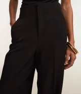 Pantalón wide leg de sastrería color negro, con corte recto, tiro alto y recorte en V en la parte trasera de la cintura.