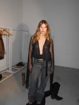 Minivestido negro de microtul con estampado de pequeñas estrellas, escote en V cruzado, mangas largas acampanadas y ajuste con lazo lateral.