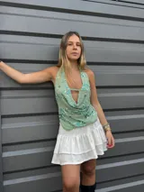 Top verde agua con escote drapeado, espalda descubierta y bordado de flores azules y lentejuelas.