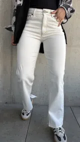 Pantalón de jean color natural, de corte recto con tajos en el lado interno de la pierna y costuras color oro.