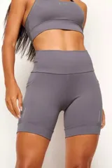 Calza biker deportiva negra, de tiro alto, con bolsillos laterales y bolsillo interno en la cintura. Presenta detalles reflectivos.