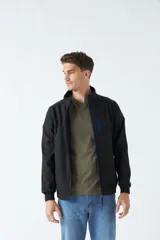 Campera softshell negra con cuello alto, resistente al viento y la lluvia, confeccionada en poliéster.