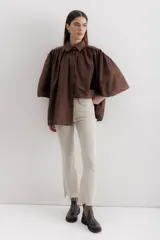 Camisa celeste de algodón con corte amplio, cuello camisero y mangas largas con puños abullonados.