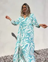 Vestido largo de corte amplio, con estampado abstracto en tonos verde agua y crudo. Tiene escote en V con lazos y mangas largas abullonadas.