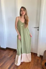 Vestido largo verde con breteles finos y corte amplio. Tiene un corte horizontal a la altura de las rodillas, con volado en color beige.