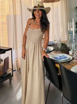 Mono largo color vino tinto, con escote smock fruncido y tirantes finos adornados con cuentas. El pantalón es de corte ancho y fluido.