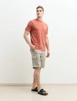 Remera verde con estampado en la espalda de una playa con palmeras y la frase "Ride the waves".