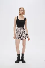 Short de poliéster con estampado abstracto en tonos beige, negro y gris. Tiene bolsillos delanteros con solapa y botón, y es de calce alto.