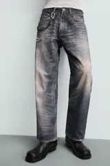 Pantalón de jean azul con lavado gastado, corte holgado y cinco bolsillos.