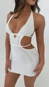 Minivestido negro tejido al crochet, con escote halter, espalda descubierta y aberturas laterales.