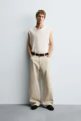 Pantalón de jean blanco, corte holgado y amplio en toda la pierna, tiro medio, tejido ligero, cinco bolsillos, efecto lavado y cierre frontal con cremallera y botón.