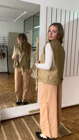 Chaleco verde de ecocuero con cuello solapa y cierre con botones a presión.