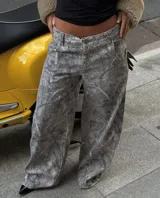 Pantalón de jean gris con estampado abstracto, corte holgado y tiro medio.