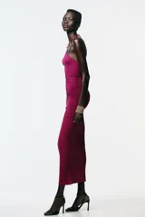Vestido color fucsia de poliamida con cuello halter con lazada y detalle de aplicación metálica en forma de sol.
