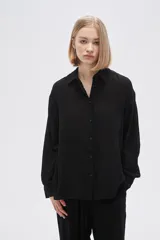 Camisa negra de viscosa plisada, corte holgado, con botones y cuello camisero.